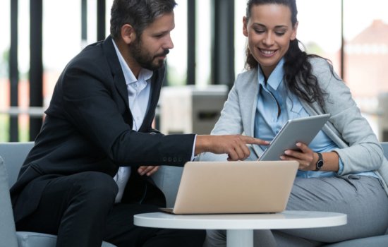 Businesspeople discussing over laptop in office premises