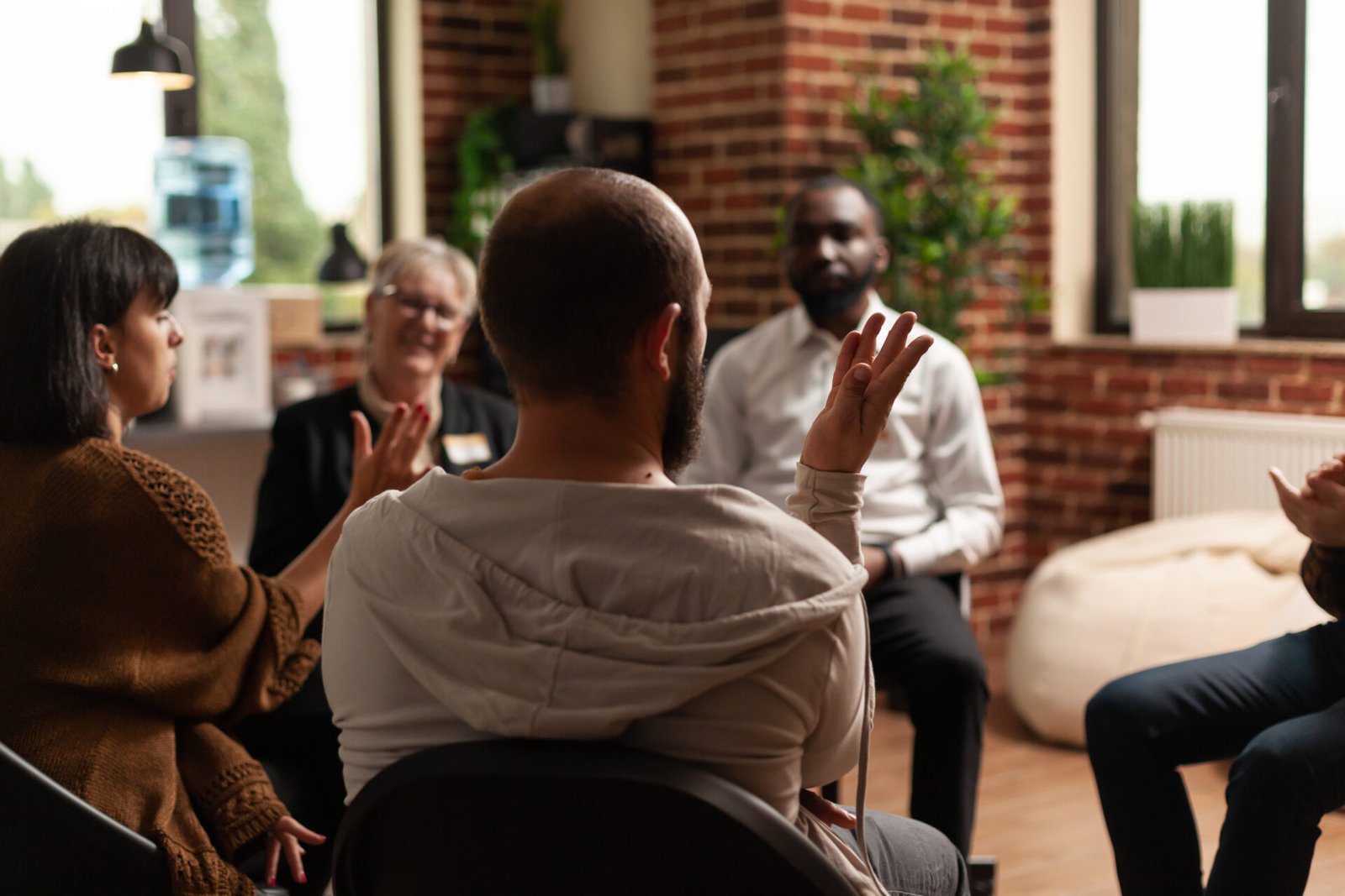 Person sharing achievement with group of people at aa meeting